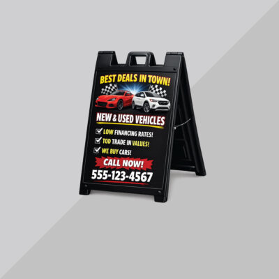 Black A-frame dealership sign advertising auto sales and financing with bold promotional text